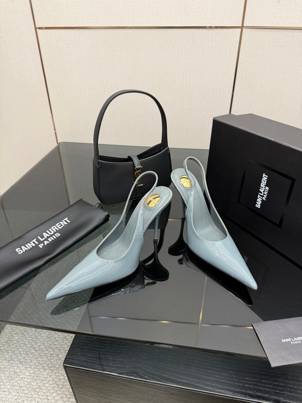 Light blue pointed-toe stiletto heels with ankle strap and glossy finish.