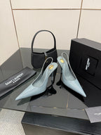 Light blue pointed-toe stiletto heels with ankle strap and glossy finish.