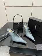 Pair of light blue slingback stiletto heels with pointed toes and slim high heels.