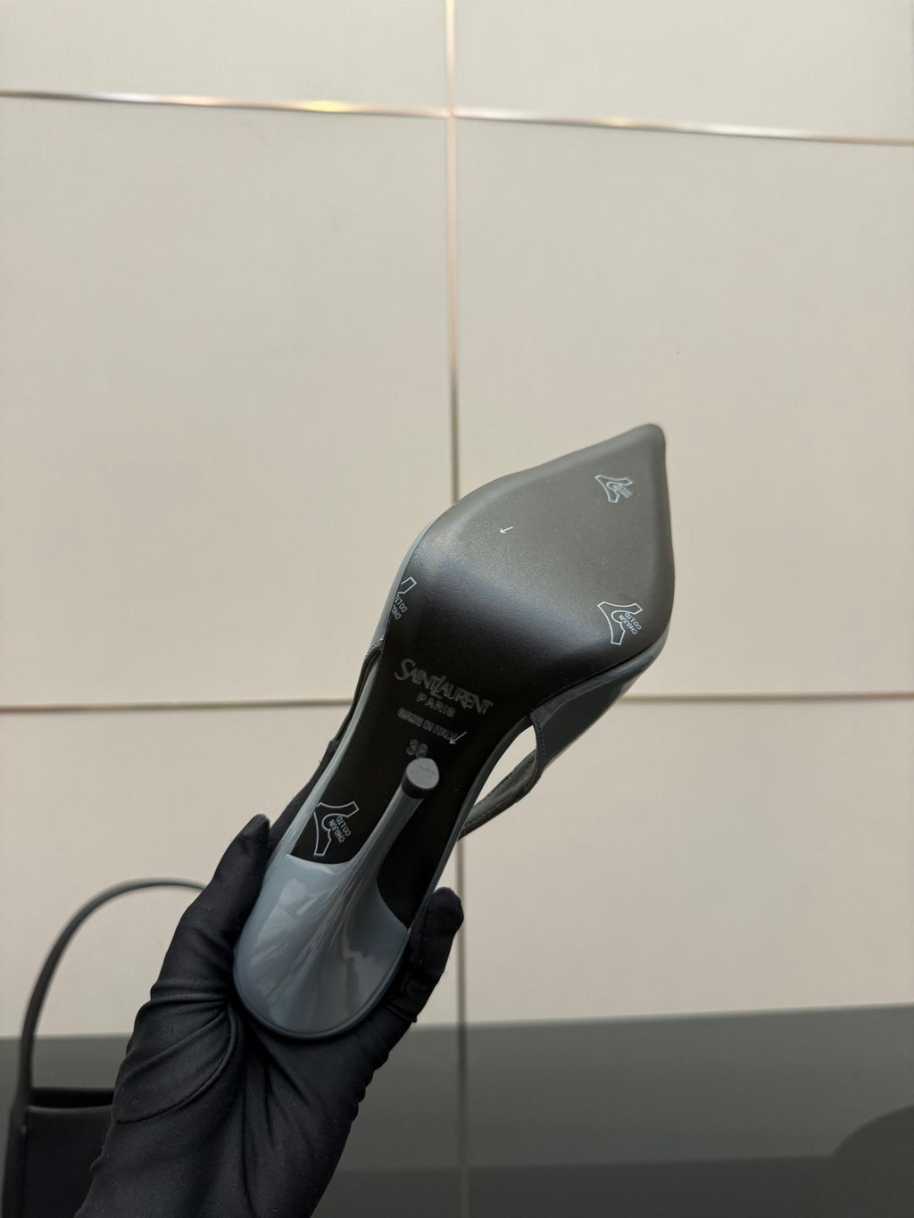 Light blue pointed-toe stiletto heel sole, held in hand, glossy finish.