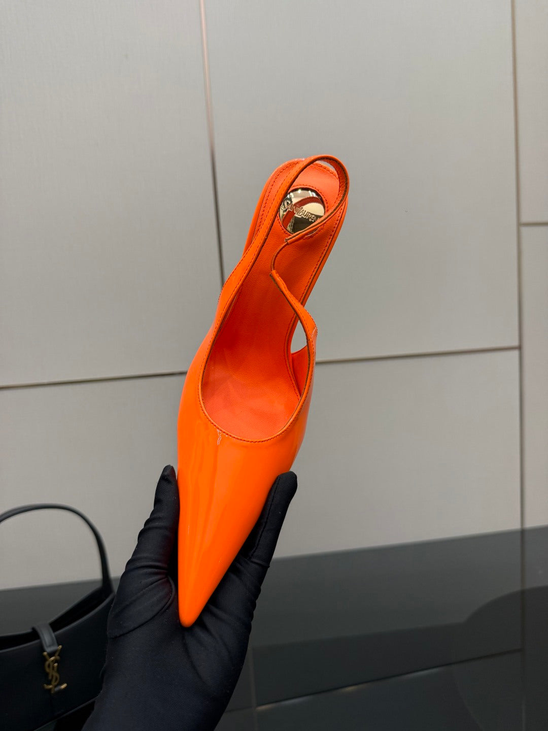 Orange high-heel slingback pump with pointed toe, glossy finish, and thin straps