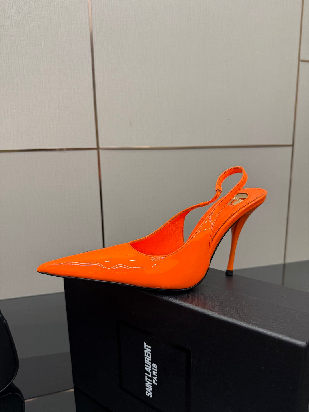 Orange pointed-toe high-heel mule-style pump with stiletto heel and curved collar