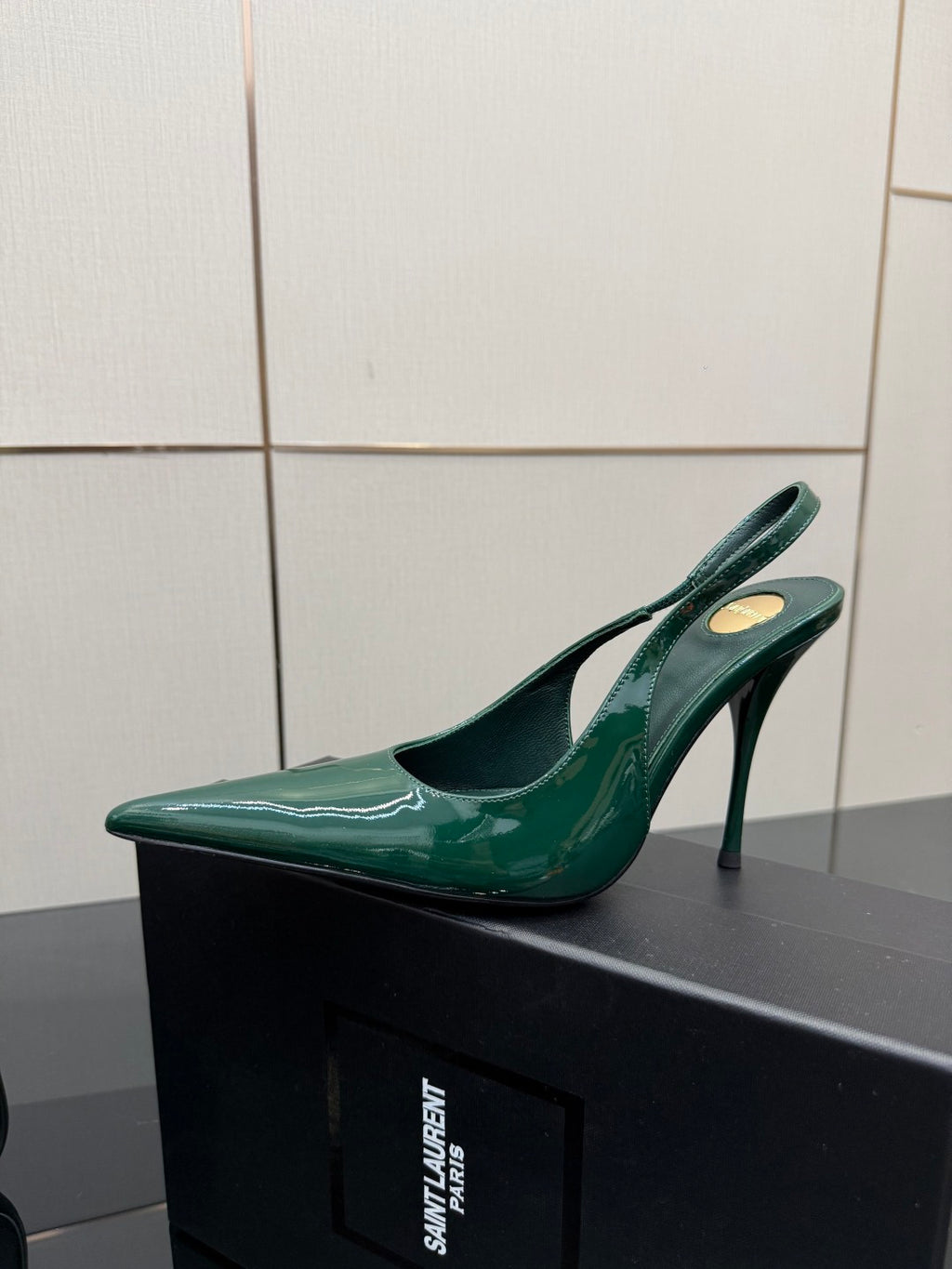 Single green patent pointed-toe slingback heel with stiletto heel, side view.