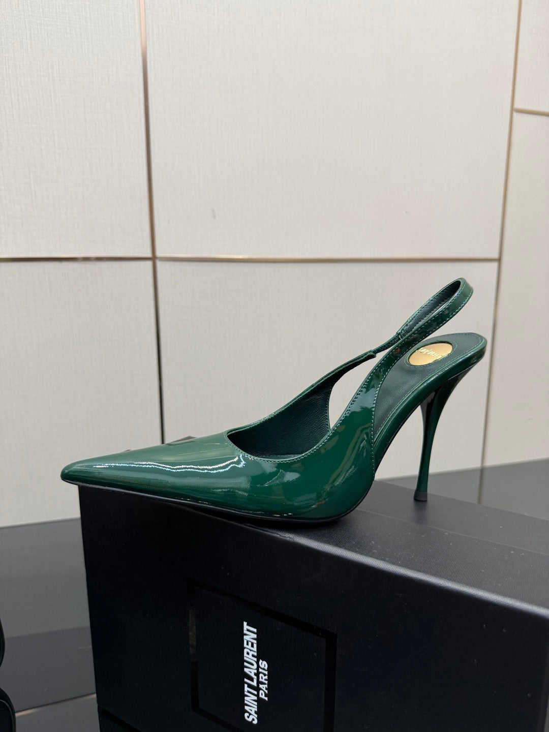 Single green patent pointed-toe slingback heel with stiletto heel, side view.