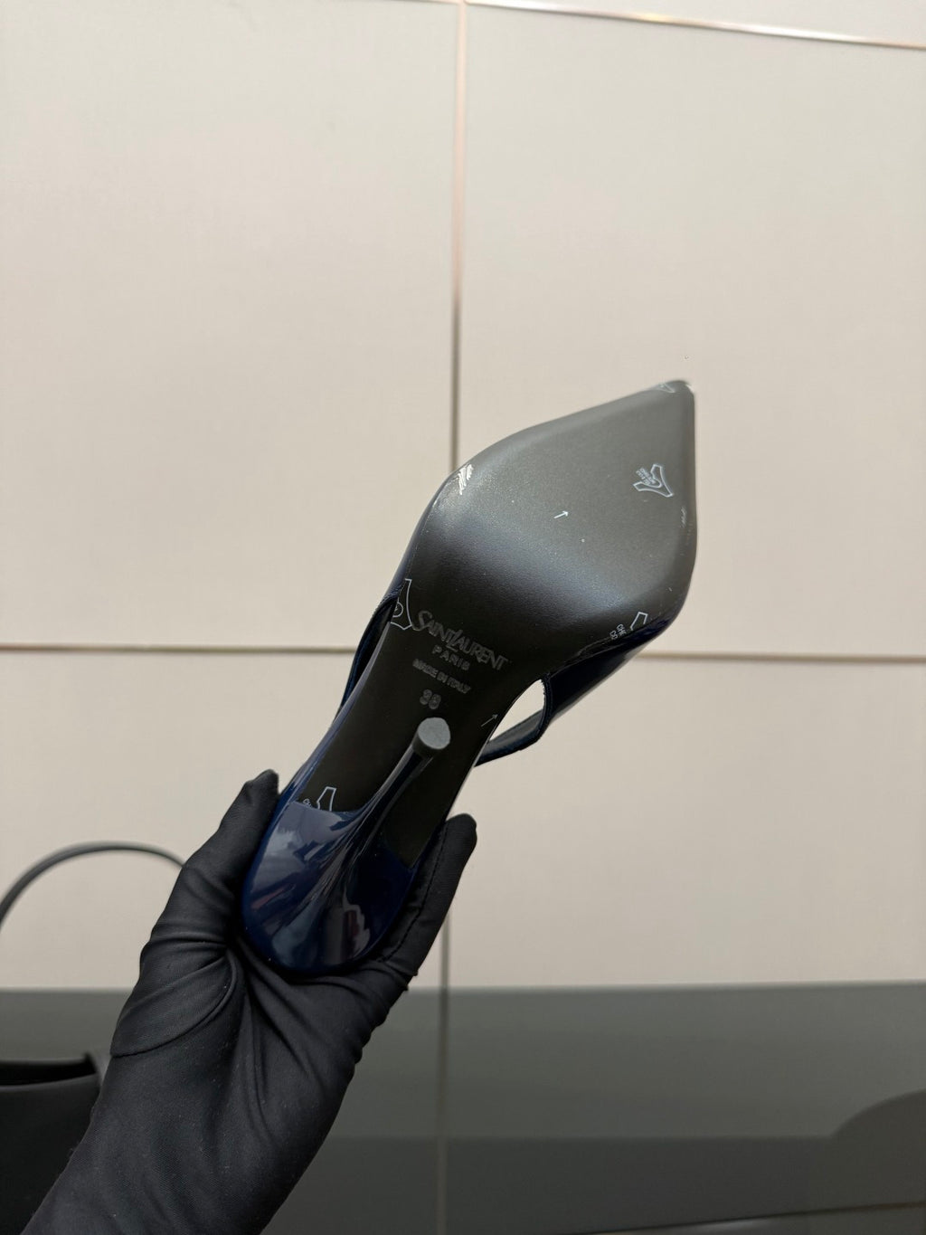 Ladies’ high-heel pump heel and sole, glossy dark blue shown in hand