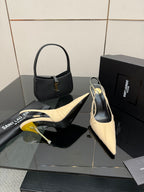 YSL slingback pumps: cream pointed toe, gold stiletto heel, shown with black handbag