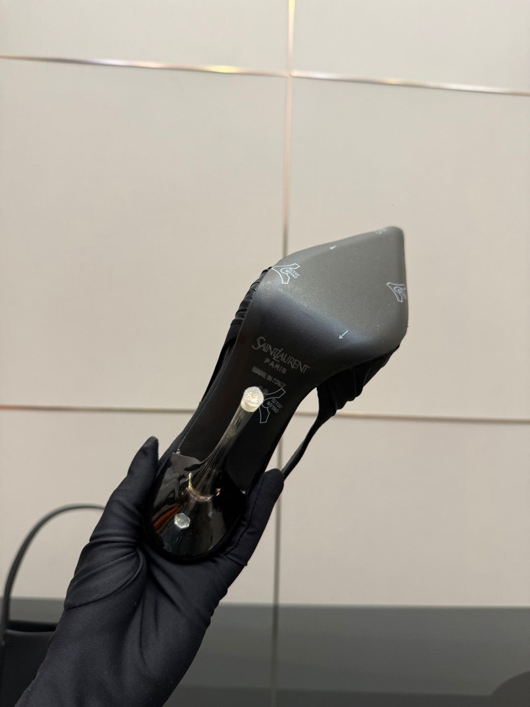 Black slingback high-heel shoe heel and side close-up, logo details visible