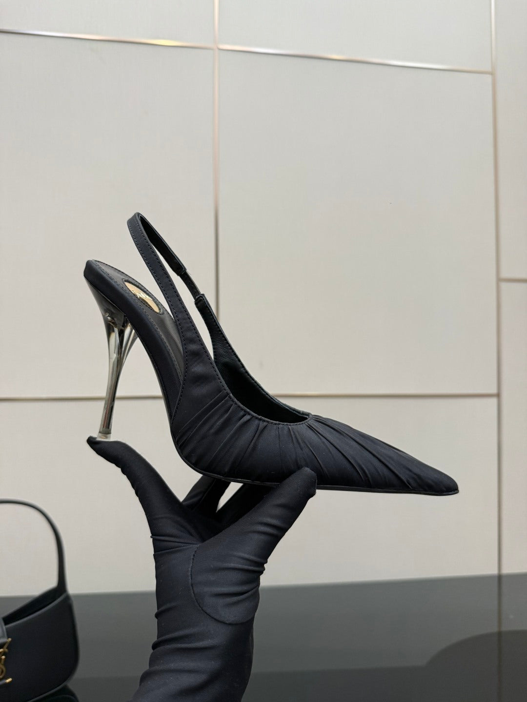 Black pointed-toe slingback high-heel shoe with silver stiletto heel, profile