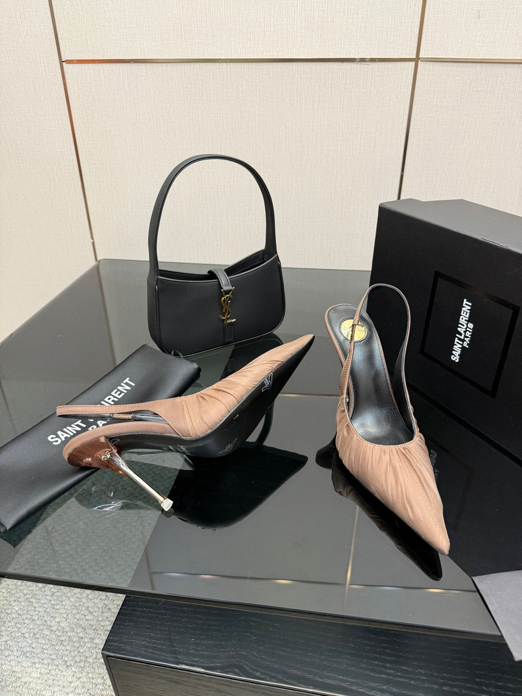 Women's nude pink slingback pumps, one heel in hand with slim stiletto profile