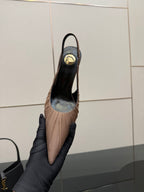 Women's nude pink slingback pump, sole and heel interior visible in hand