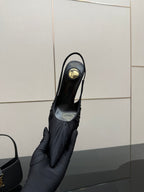Black pointed-toe slingback high-heel shoe held up, back and heel view