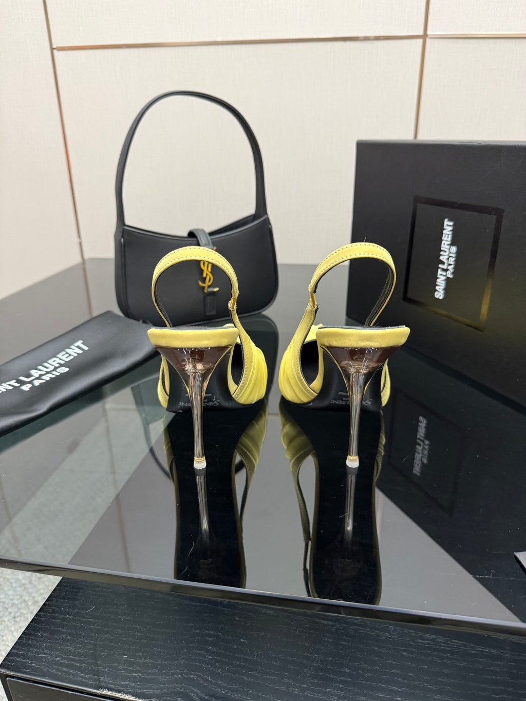 Yellow slingback stiletto heels with pointed toes and tall metal heels, on display
