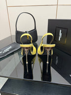 Yellow slingback stiletto heels with pointed toes and tall metal heels, on display
