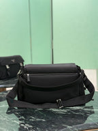 Black Prada crossbody bag with front flap, adjustable strap, and top handle.