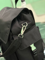 Black Prada bag interior opening with metal clasp, zipper pulls, and fabric lining.