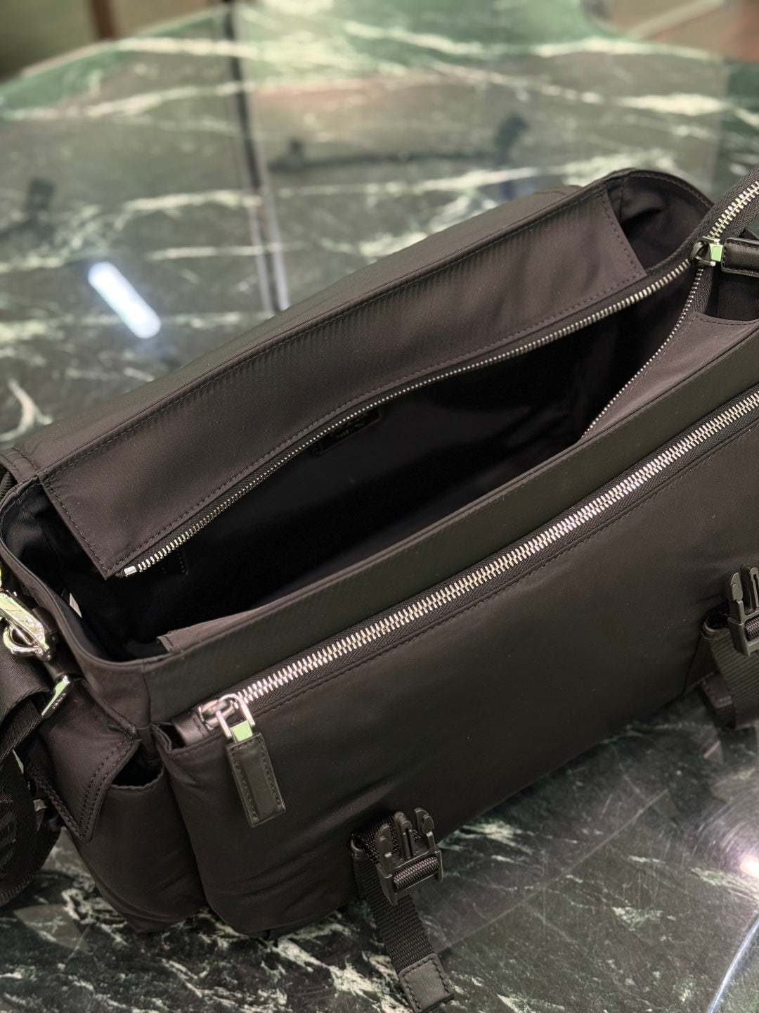 Black Prada bag open view with dual zippers and interior lining.