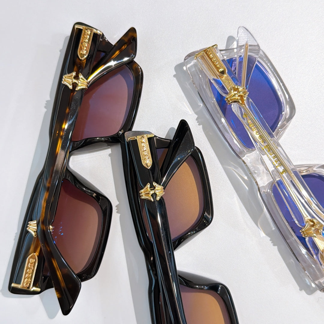 Assorted sunglasses: dark frames with tinted lenses and clear blue frame with purple tint