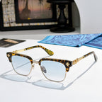 Chrome-framed glasses with tortoiseshell arms, gold accents, and light blue lenses