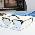 Chrome-framed glasses with black temples, gold accents, and light blue lenses