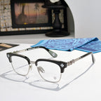 Metal eyeglasses with clear lenses, black frame, and silver-toned side details