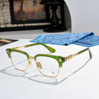 Metal eyeglasses with clear lenses, green frame, and gold-toned decorative temples