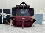 Burgundy suede Prada bag with front flap, gold hardware, and shoulder straps