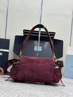 Burgundy suede Prada tote-style bag with top handles, flap front, and gold trim