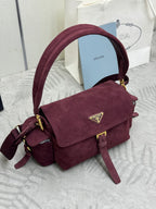 Burgundy suede Prada crossbody bag with front flap, gold clasp, and adjustable strap