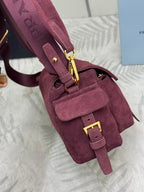 Burgundy suede Prada mini bag with front pocket, gold chain accents, and zip closure