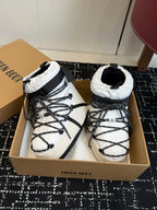 White and black lace-up snow boots with padded cuffs and crisscross laces