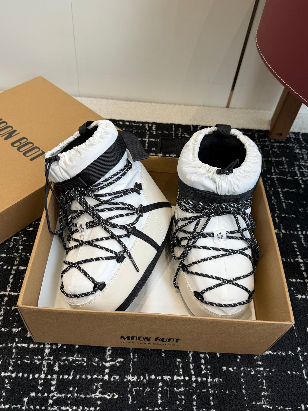 White and black lace-up snow boots with padded cuffs and crisscross laces
