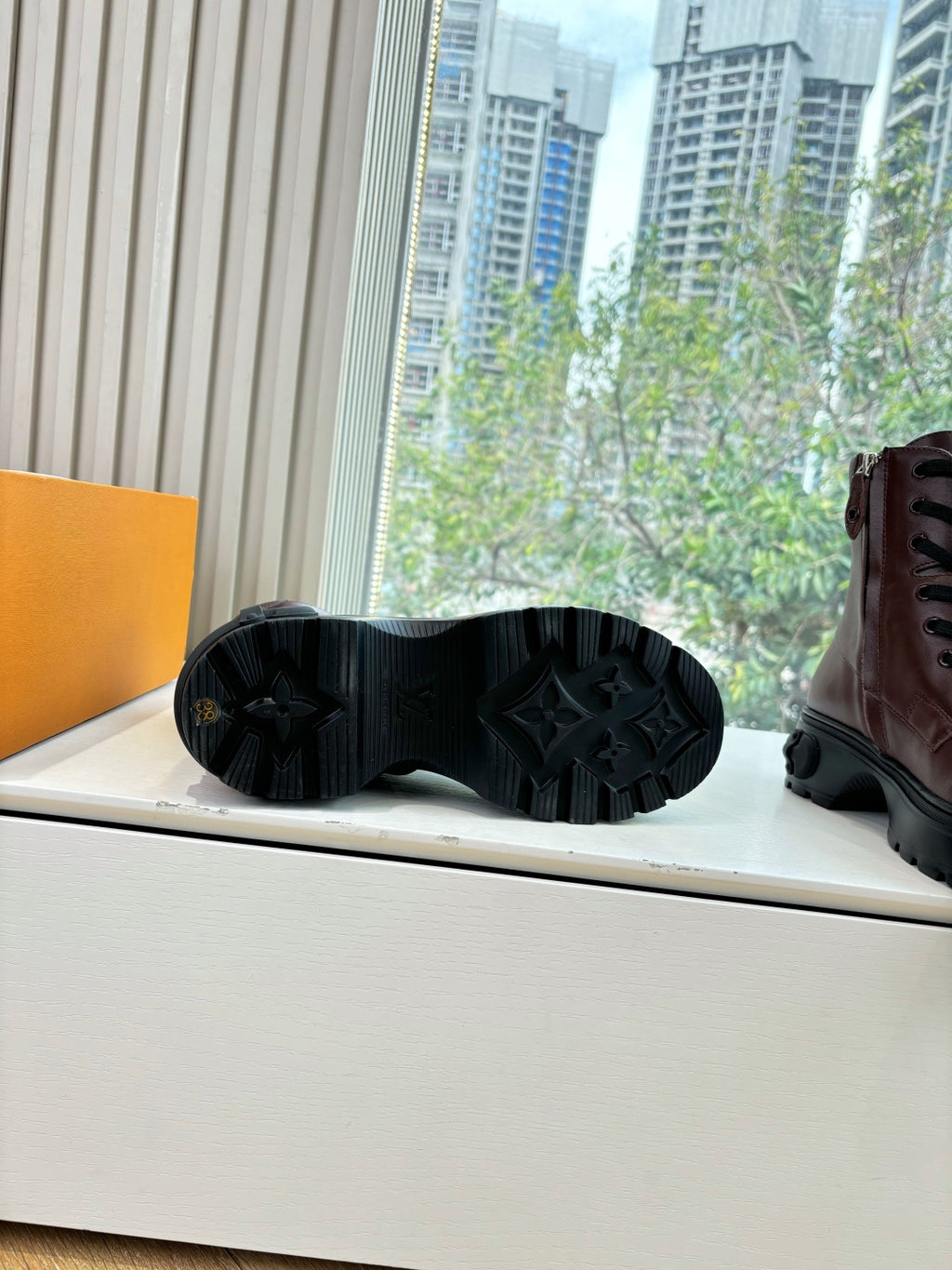 Black boot outsole tread with lace-up boot side partly visible