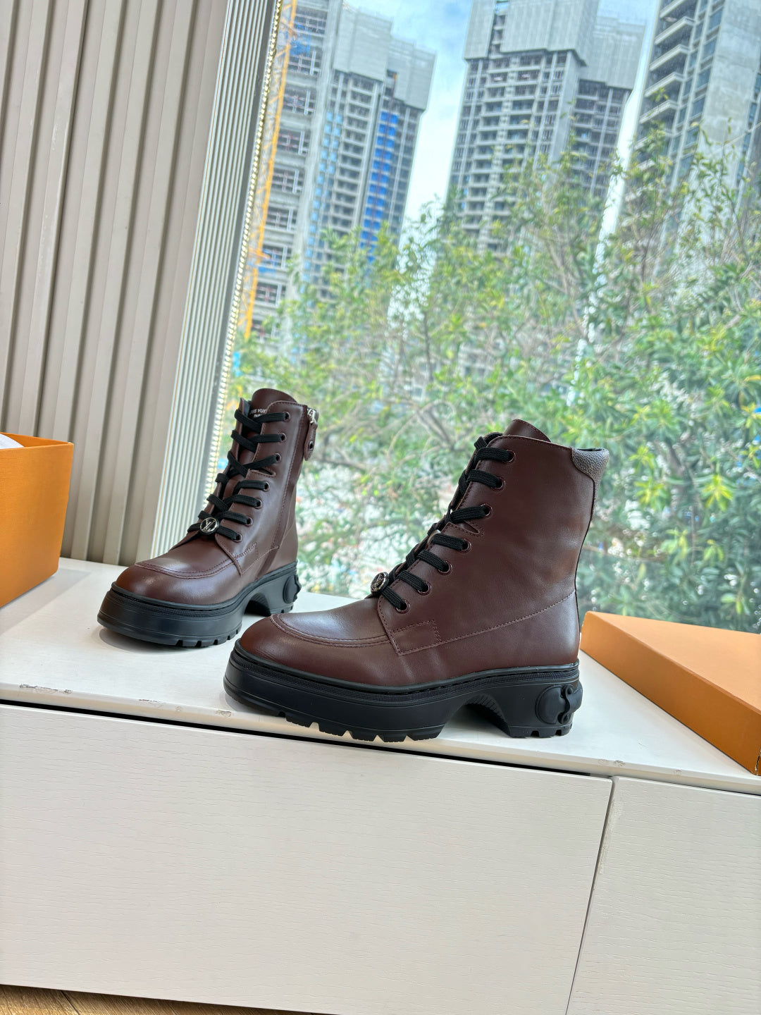 Brown leather lace-up ankle boots with thick black rubber sole