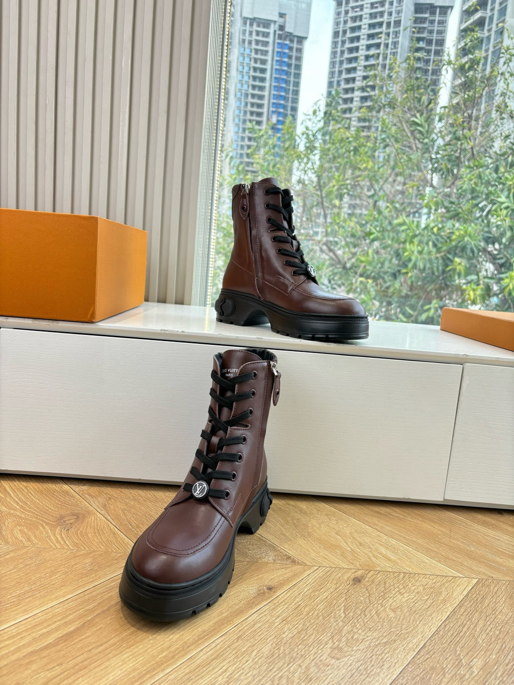 Brown leather lace-up boots with black sole, angled front view