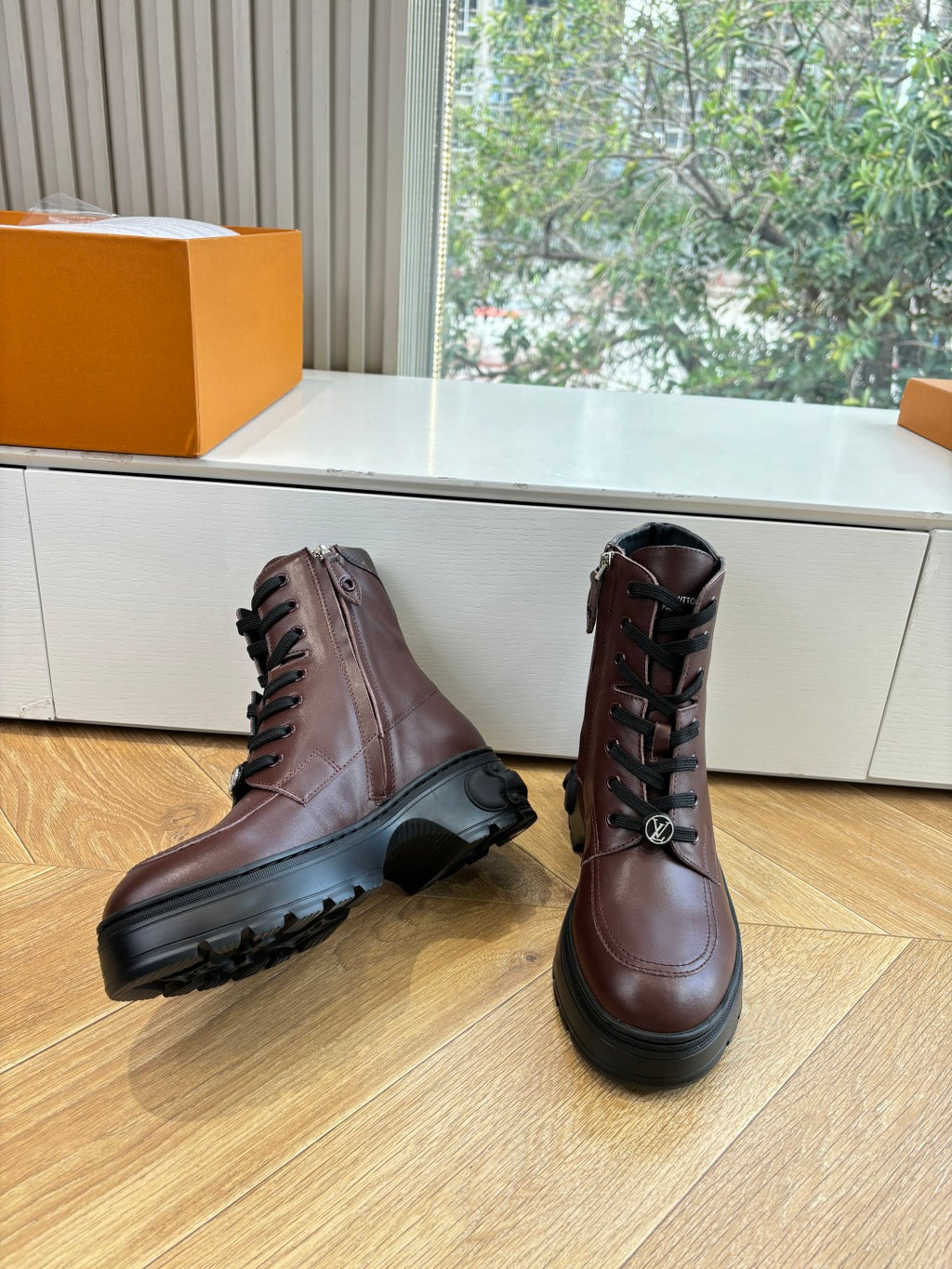 Brown leather lace-up ankle boots with black lug sole and laces