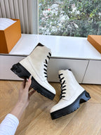White leather lace-up ankle boots with black laces and padded collar