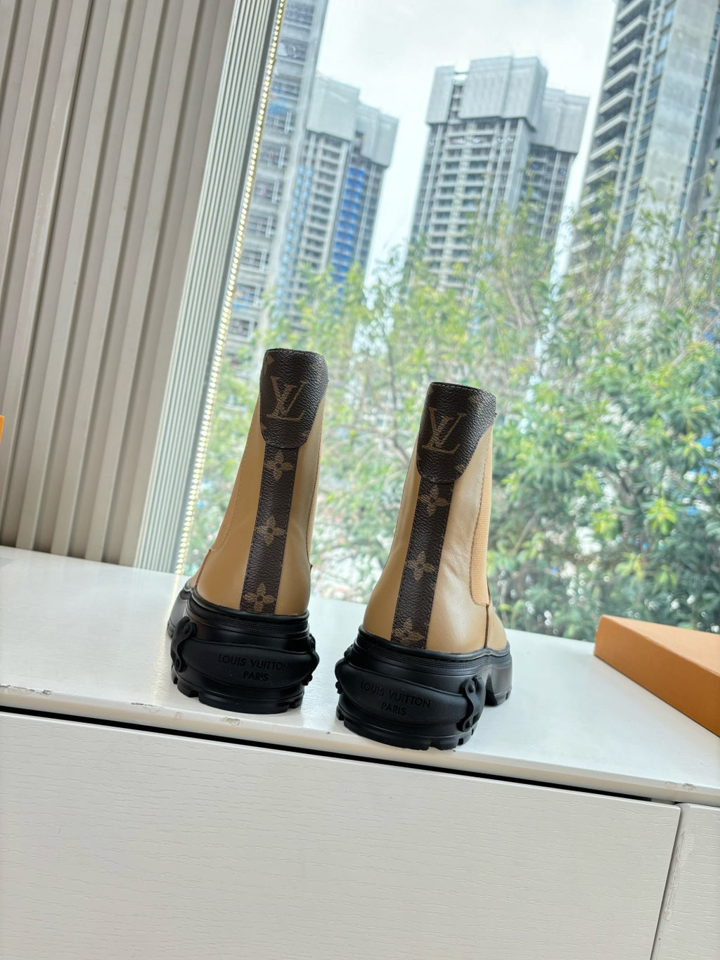 Brown monogram Chelsea boots with elastic sides and chunky black rubber sole.