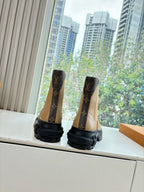 Brown monogram Chelsea boots with elastic sides and chunky black rubber sole.