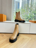 Tan leather Chelsea boot with elastic side panels and black lug sole.