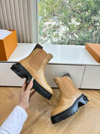 Tan leather Chelsea boots with elastic side gore and chunky black outsole.