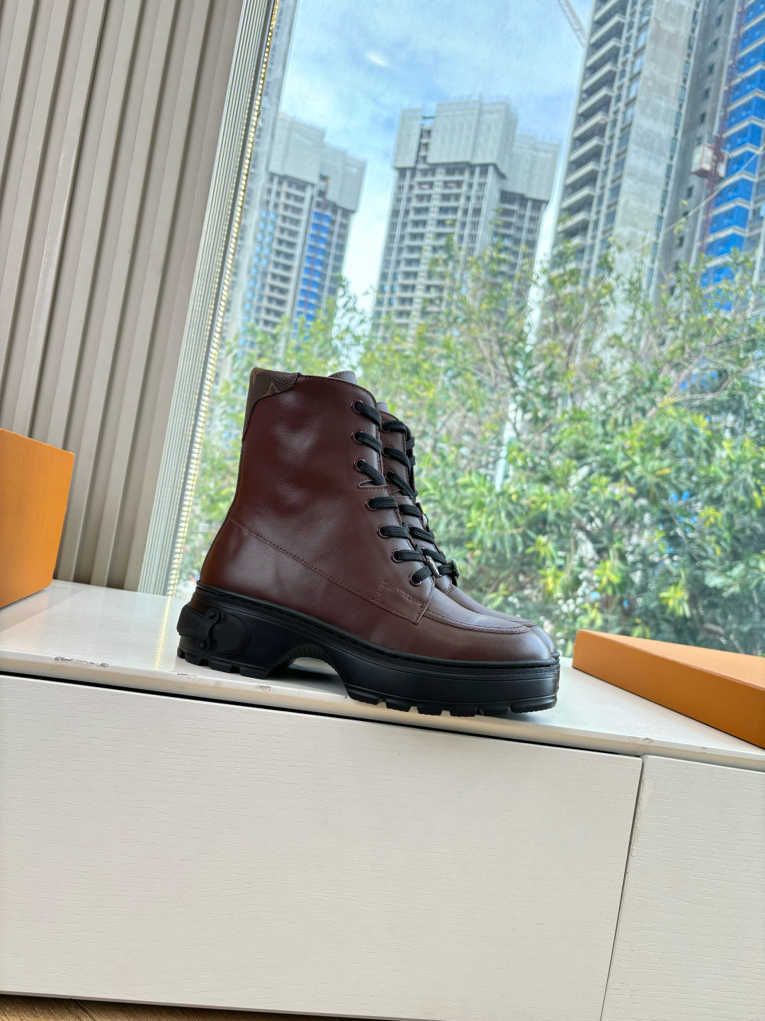 Brown leather lace-up ankle boots, side view with black sole