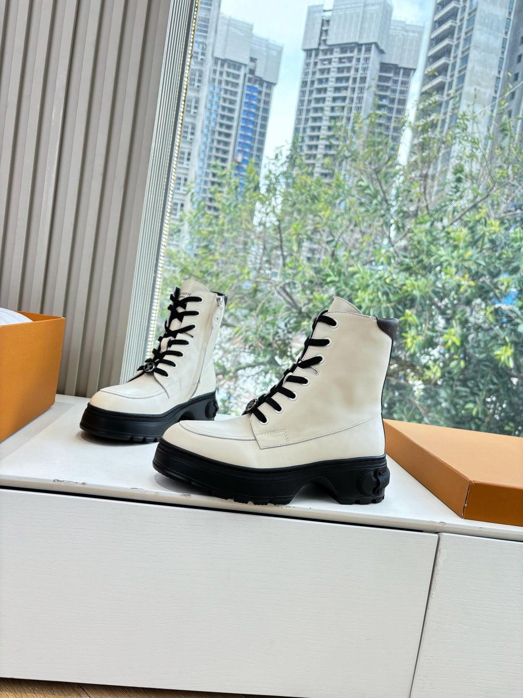 White leather ankle boots, black lace-up front, thick treaded black soles