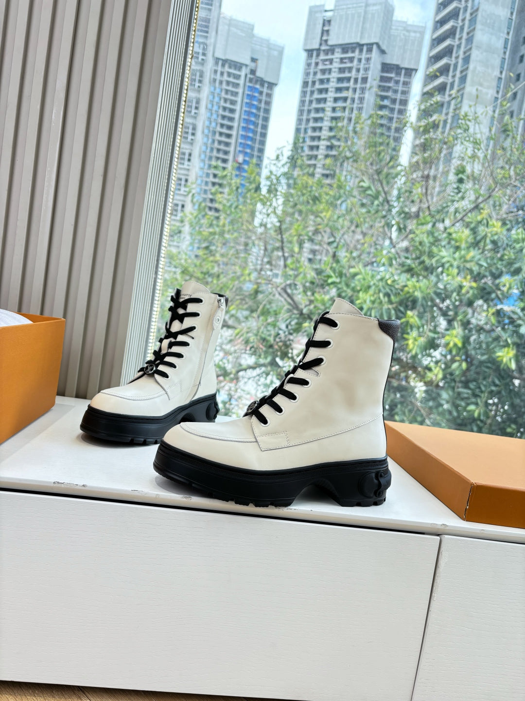 White leather ankle boots, black lace-up front, thick treaded black soles