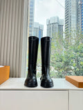 Black leather knee-high boots with thick rubber sole, front view