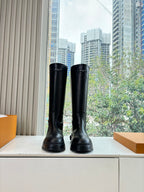 Black leather knee-high boots with thick rubber sole, front view