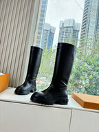 Black knee-high leather boots with side profile and chunky sole