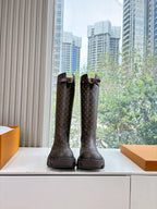 Louis Vuitton monogram tall boots with buckle straps and lug soles, rear view of pair