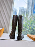 Louis Vuitton monogram tall boots with buckle straps and lug soles, front view of pair