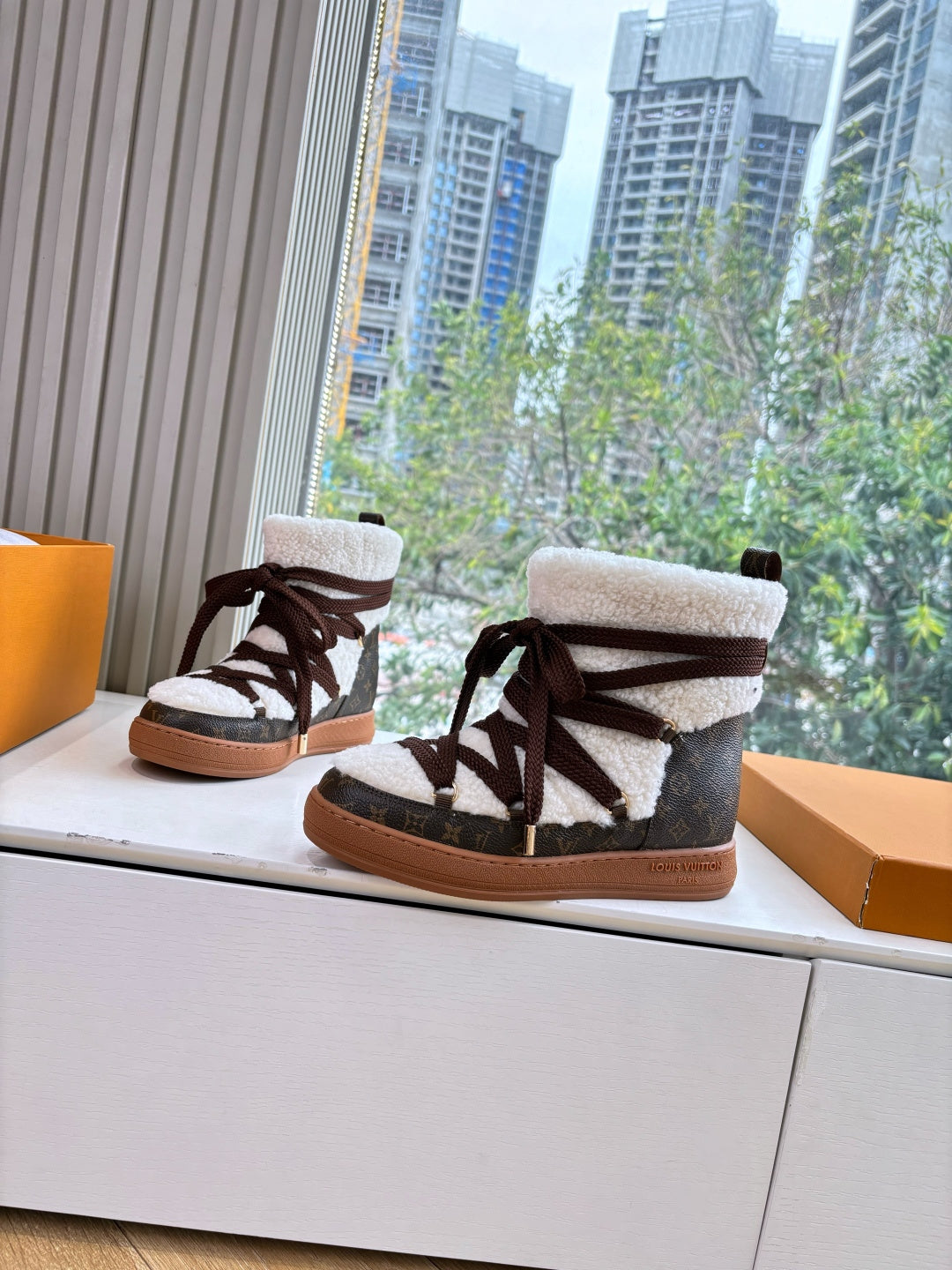 High-top sneakers with faux shearling cuffs, dark laces, and tan gum soles