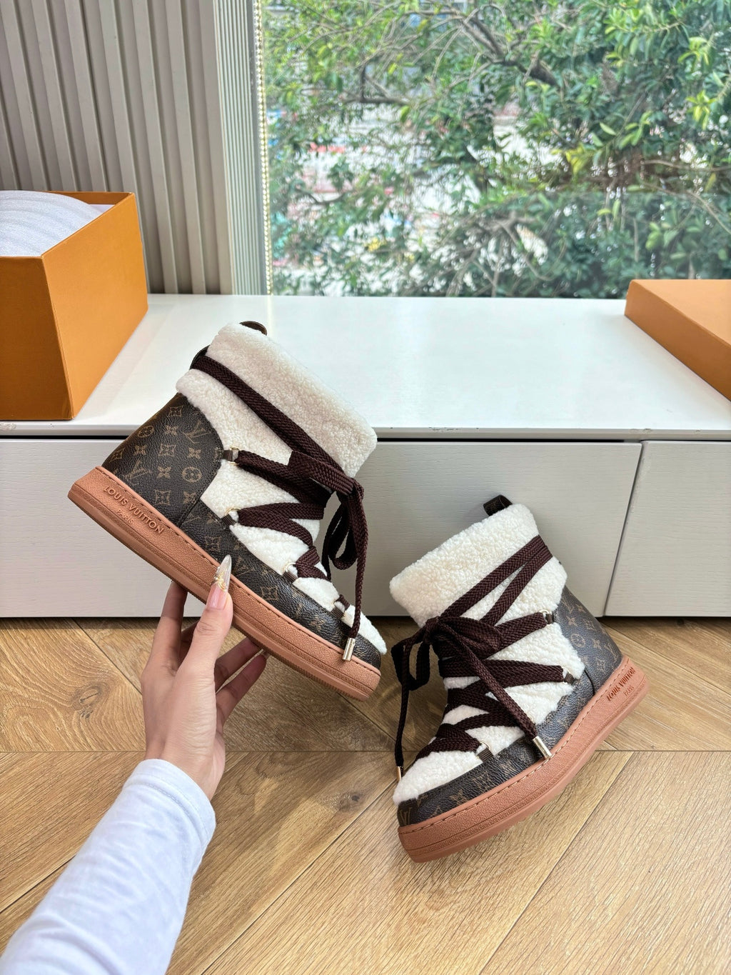 High-top sneakers with shearling collar, dark laces, and tan rubber soles